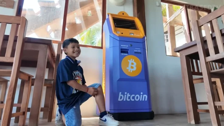 A woman demonstrating how to use a Bitcoin ATM.