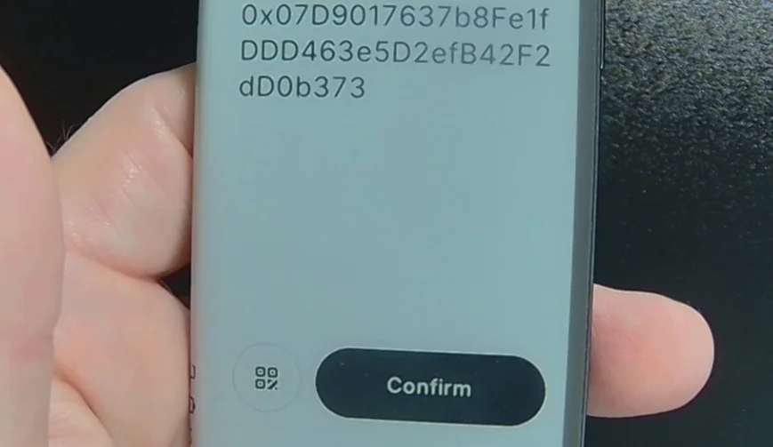 Close-up of a Ledger device screen displaying the full Ethereum address and a 'Confirm' button.