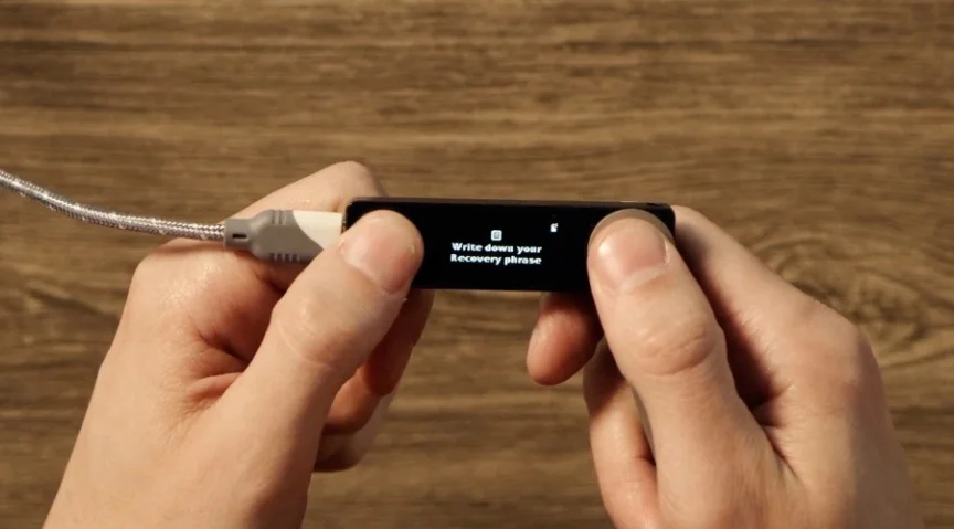The Ledger Nano X screen displaying 'Write down your Recovery phrase'.