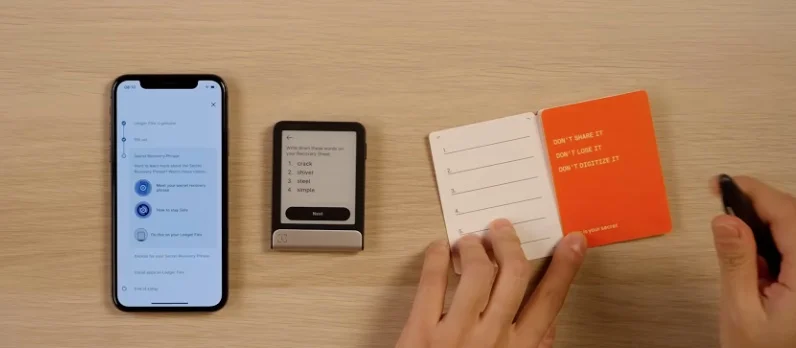 The user filling in the recovery words on a physical orange recovery sheet